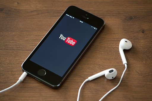 Ein Handybildschirm mit YouTube-Icon stellt rechtssichere Werbung dank Anwalt für Online Marketing dar 
